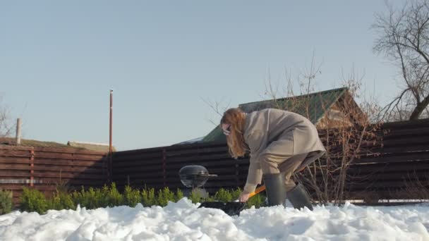 Mujer limpia nieve en el patio - Metraje, vídeo