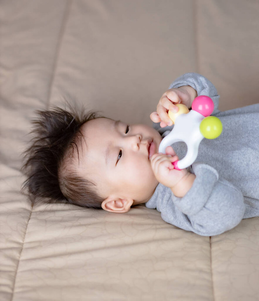 Χαριτωμένο μωρό παίζει με πολλά πολύχρωμα παιχνίδια κουδουνίστρα - Φωτογραφία, εικόνα