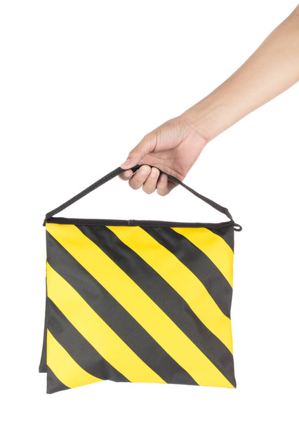 Hand holding Equipment Black Yellow Sandbag For Stand Tripod geïsoleerd op witte achtergrond - Foto, afbeelding