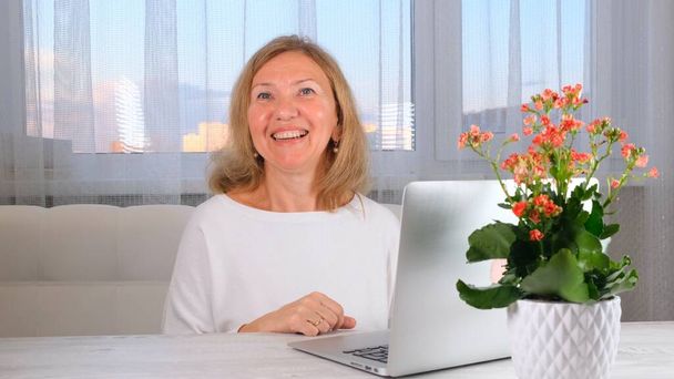 усміхнена елегантна жінка з відеодзвінком на ноутбук. Концепція комунікації
. - Фото, зображення