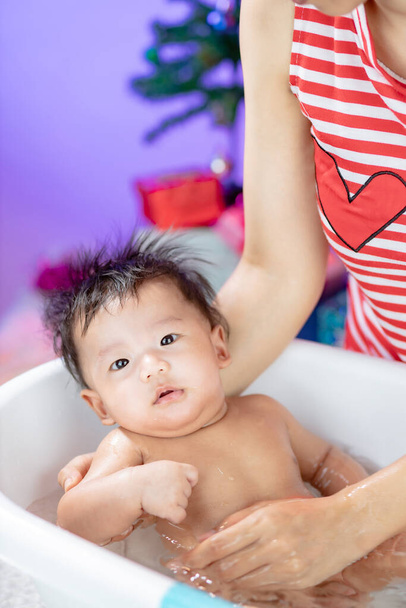 Pequeno bebê tendo um banho na bacia pela mãe - Foto, Imagem