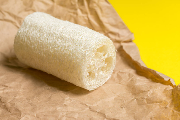 Luffa spons voor het wassen of bad op een gele achtergrond. milieuvriendelijk - Foto, afbeelding