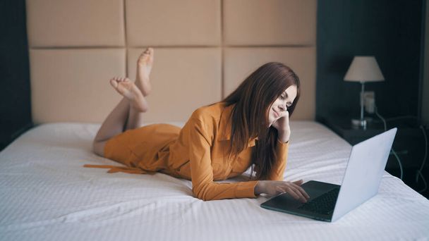 γυναίκα στο δωμάτιο βρίσκεται στο κρεβάτι φορητό υπολογιστή εργασίας τεχνολογία lifestyle - Φωτογραφία, εικόνα