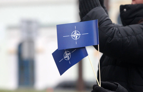 Флаг НАТО в руке, символ - Фото, изображение