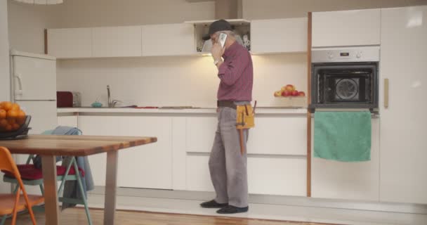 Starší muž mluví se svými zákazníky o opravách domu - Záběry, video