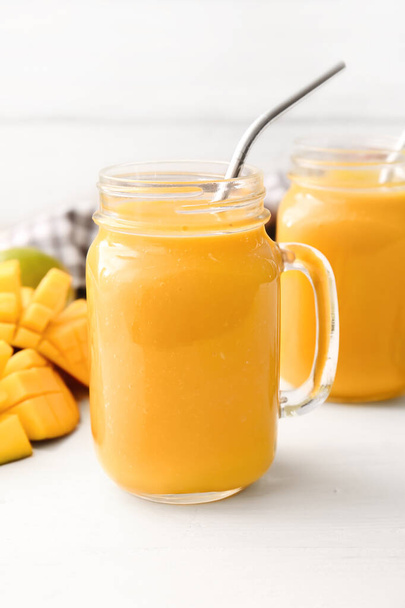 Mason kavanozları hafif arka planda lezzetli mango smoothie - Fotoğraf, Görsel