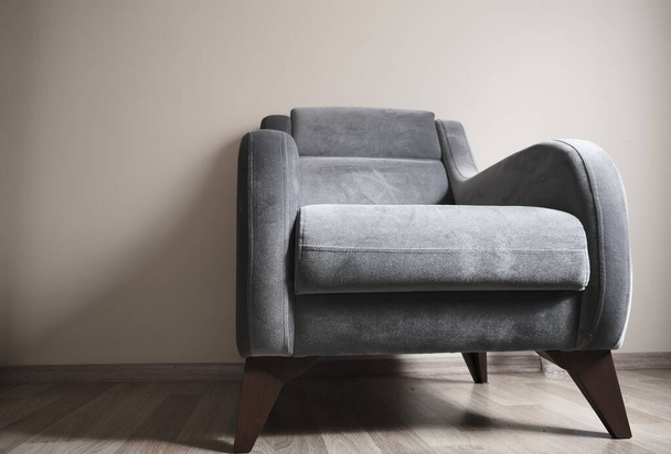 Kleurrijke foto van enkele zetel en minimalisme symbool. Oude vintage en retro stijl eenpersoonsstoel staand op houten vloer en zijn benen gemaakt van houten materiaal. Klein en een kussen op de stoel. - Foto, afbeelding