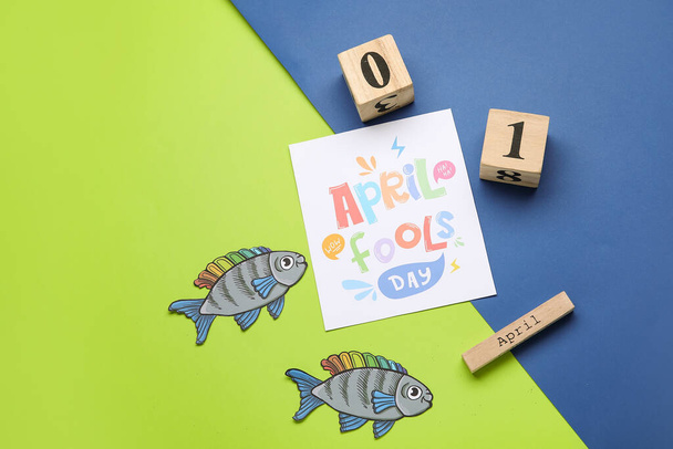 Бумажные рыбы и календарь с датой апреля День дураков на цветном фоне - Фото, изображение