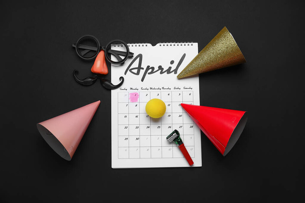 Decoração de festa e calendário com data de abril Fools Day no fundo escuro - Foto, Imagem