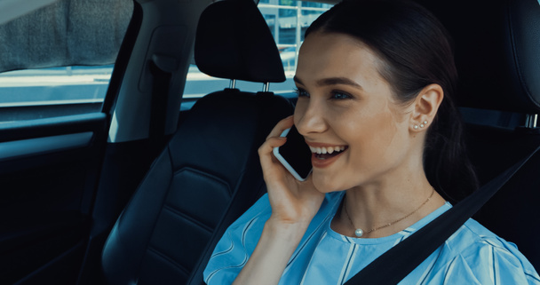 Neşeli kadın arabanın içinde akıllı telefondan konuşuyor. - Fotoğraf, Görsel