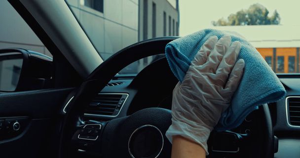 обрізаний вид жінки в латексній рукавичці дезінфікує кермо з ганчіркою
 - Фото, зображення