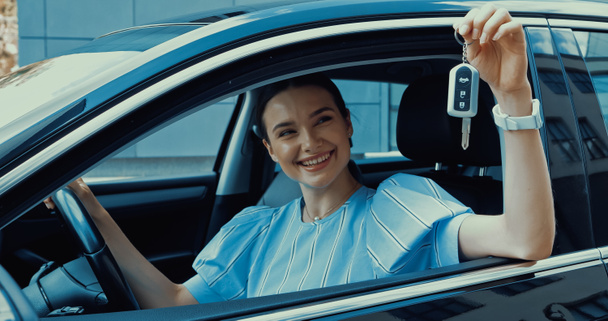 veselá mladá žena držící klíč z nového auta - Fotografie, Obrázek