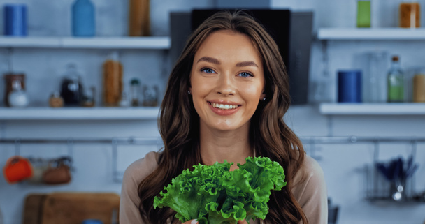 felice giovane donna che tiene lattuga verde e fresca - Foto, immagini