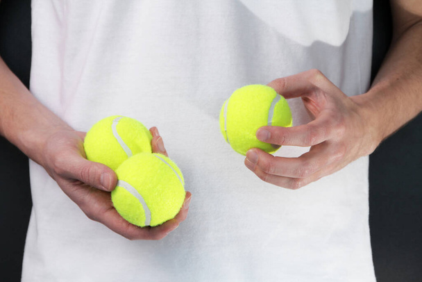 Een man in een sportuniform heeft ballen. tennissen. close-up - Foto, afbeelding