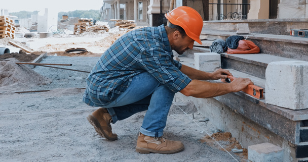 Constructeur mesurant le terrain avec le niveau du bâtiment sur le chantier - Photo, image