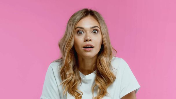 Shocked blonde woman looking at camera isolated on pink - Foto, Imagem