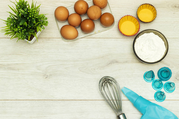 Yumurta, un ve kek dekorasyon araçları ile kopyalama alanı, krema torbası ve ucu veya ahşap masa kırbaç - Fotoğraf, Görsel