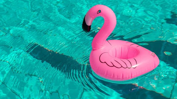 Fondo marino. Flamenco inflable rosa en el agua de la piscina para el fondo de la playa de verano. Estilo de vida de lujo - Foto, Imagen