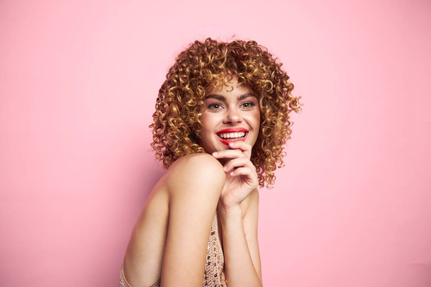 šťastný úsměv žena s kudrnaté vlasy na růžovém pozadí - Fotografie, Obrázek