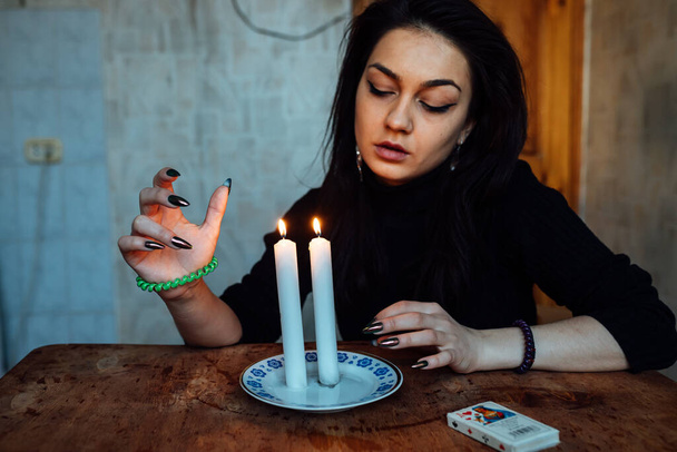 Ένας μάντης κοιτάζει μια φλόγα κεριού, ένα μαγικό τελετουργικό για την πρόβλεψη του μέλλοντος. - Φωτογραφία, εικόνα