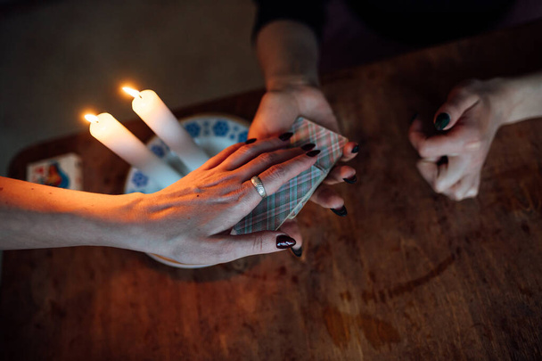 Válasszon egy kártyát egy jövendőmondó kezéből. Egy nő jövőt jósol egy mágikus rituálé során. hit a miszticizmusban - Fotó, kép