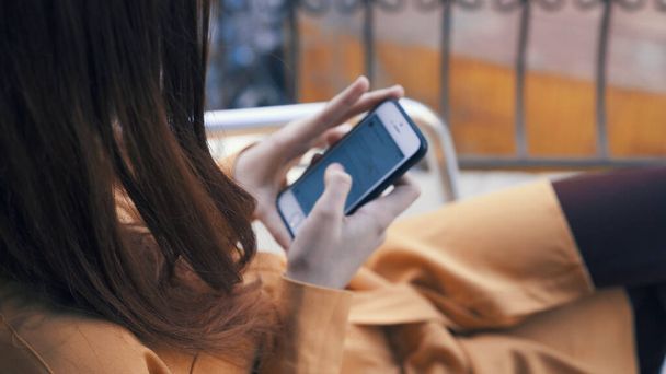 femme avec un téléphone dans ses mains assis dans un café repos communication - Photo, image