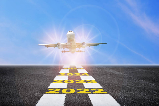 Αεροπλάνο ανάκαμψη των επιχειρήσεων μετά covid-19 αντίκτυπο στον κλάδο των μεταφορών έννοια κρίσης και την ιδέα των επαγγελματικών ταξιδιών. Έτος 2022 έως 2025 για διάδρομο με εμπορικό αεροπλάνο στο μπλε φόντο του ουρανού - Φωτογραφία, εικόνα