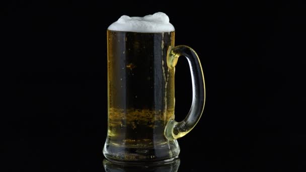 Легкое пиво в стакане на черном фоне - Кадры, видео