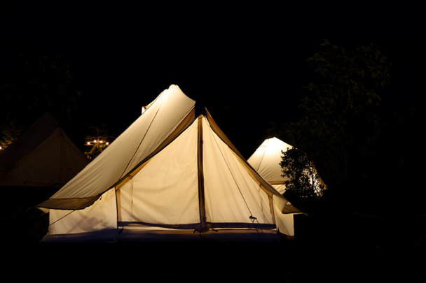La tienda blanca está acampando en el jardín por la noche - Foto, imagen