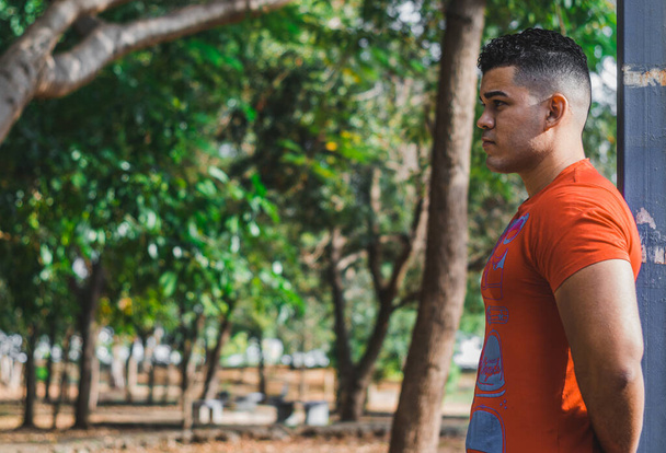 Modelo masculino de pele branca de origem venezuelana na República Dominicana. sexy homem em jeans no parque ao ar livre com laranja anda - Foto, Imagem