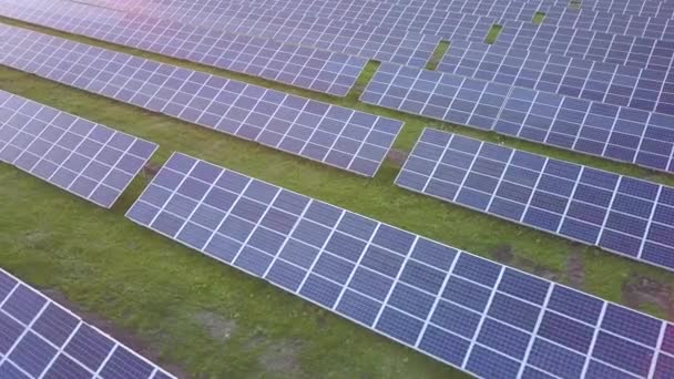 Letecký pohled na zelené pole se solárními panely pro výrobu elektřiny z obnovitelných zdrojů. - Záběry, video