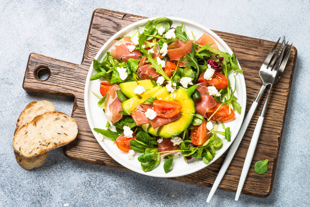 Fresh salad with green leaves, jamon and tomatoes. - Photo, Image