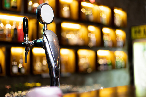 Dávkovač piva, Dávkovač piva sedí na polici před vinobraním baru s pivem nebo likérem na pozadí a krásné bokeh světla, Alkoholické nápoje v hospodě na víkendový večírek. - Fotografie, Obrázek