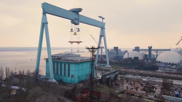 Enorme grúa de carga en astillero con graneros metálicos en terminal comercial portuaria internacional - Imágenes, Vídeo