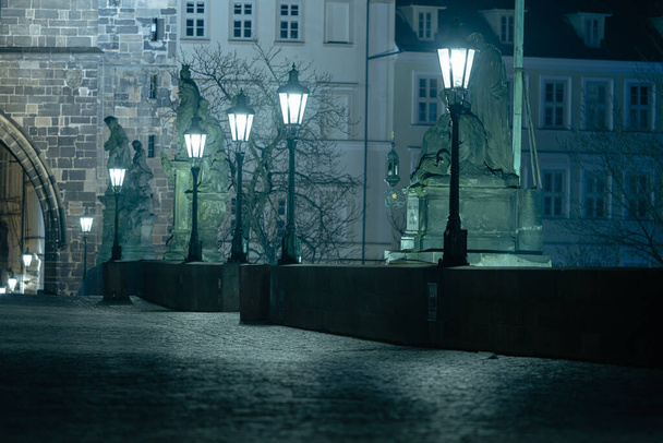 夜にはヴルタヴァ川に架かる空のカレル橋とプラハの中心部にある石造りの橋塔に灯火が灯ります。 - 写真・画像