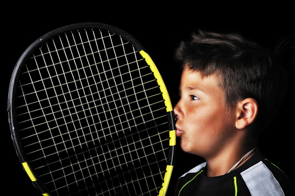 Handsome boy with tennis equipment kissing racquet - Fotó, kép