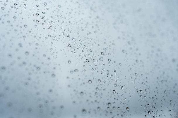 Lluvia cayendo por la ventana. Cristal con gotas en otoño de cerca, estar cómodo en casa - Foto, Imagen