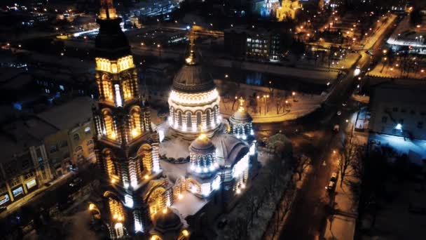 Fly γύρω από τον καθεδρικό ναό Ευαγγελισμού φωτίζεται το χειμώνα χιονισμένα φώτα νύχτα. Αεροφωτογραφία Χάρκοβο πόλη ορθόδοξο θέαμα εκκλησία, Ουκρανία. Παράπλευρη θέα από αέρα. Κύρια πόλη ορόσημο - Πλάνα, βίντεο