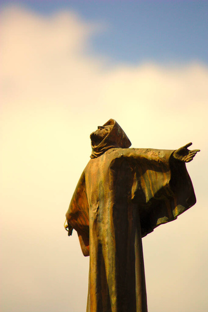 Detail of the stone statue of a Franciscan monk San Francisco who looks to the sky looking for God in the city of L`Alcora, Castelln, Spain - Photo, Image