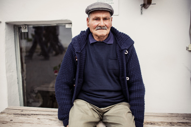 stary człowiek na stanowisku w alberobello - Zdjęcie, obraz