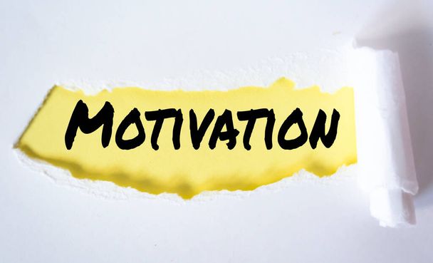 Het woord Motivatie verschijnt achter gescheurd wit papier. - Foto, afbeelding