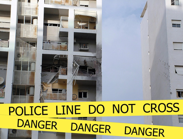politie lijn overschrijden geen teken tape op beschadigd door explosie gebouw achtergrond - Foto, afbeelding