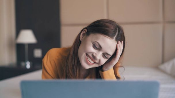 usmívající se žena ležící před notebookem internet volnočasové komunikační technologie - Fotografie, Obrázek