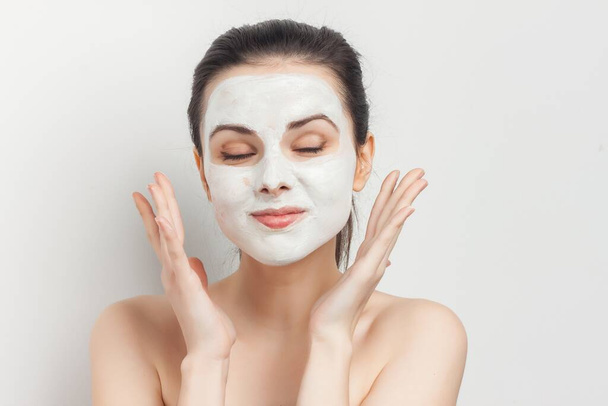 vrouw met gezichtscrème masker huidverzorging naakt schouders spa behandelingen - Foto, afbeelding