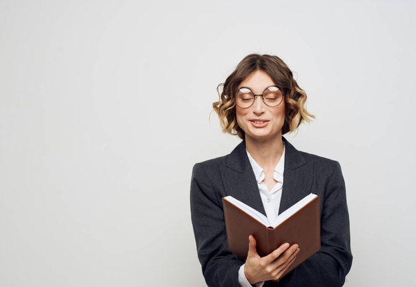 Woman in classic suit with open book glasses on face cropped view - 写真・画像