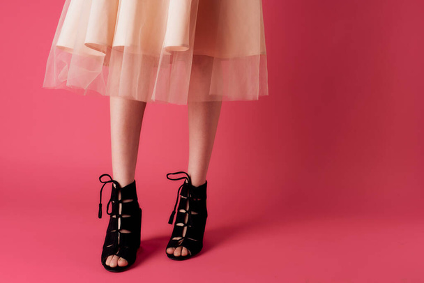 Female legs in dress fashionable shoes luxury pink background - Foto, imagen
