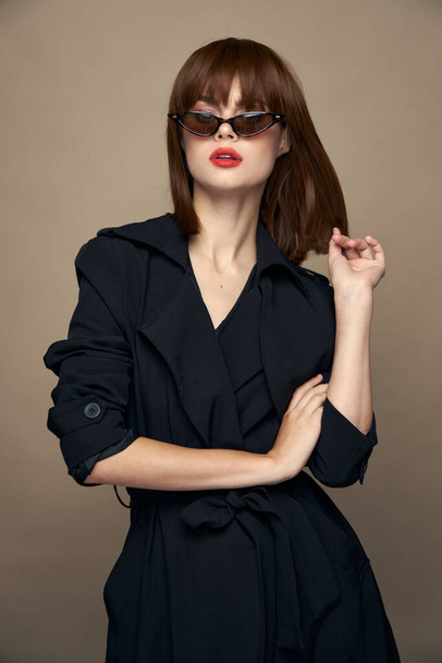 Stylish Woman Red lips sunglasses black coat isolated background - Foto, afbeelding