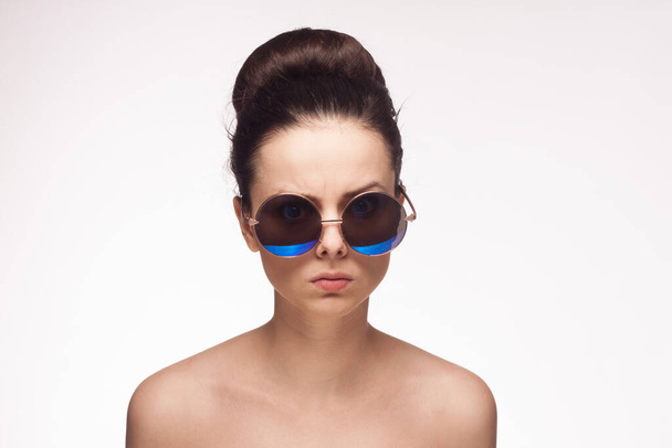 mujer bonita hombros desnudos gafas de sol glamour fondo claro - Foto, Imagen