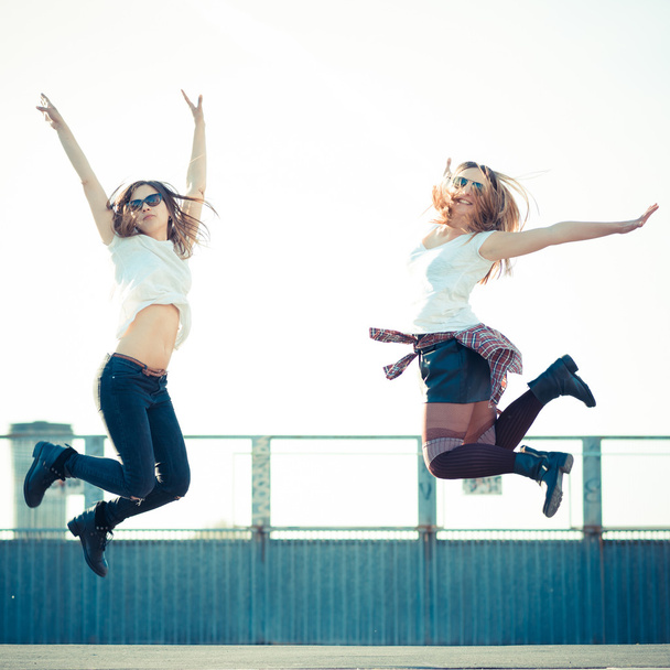 Duas mulheres bonitas pulando
 - Foto, Imagem