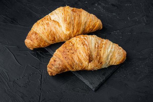 Frissen sült croissant set, fekete kő háttér - Fotó, kép